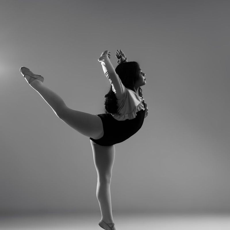 A focused person performing a controlled, graceful movement.